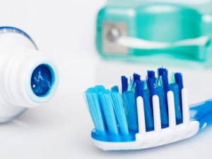close up of a toothbrush, toothpaste and dental floss