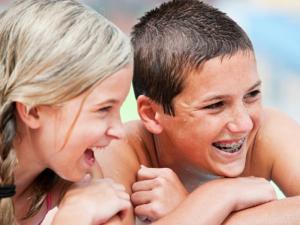 Milton Orthodontics Teens Swimming and Laughing, Teen Boy is wearing metal braces and laughing  
